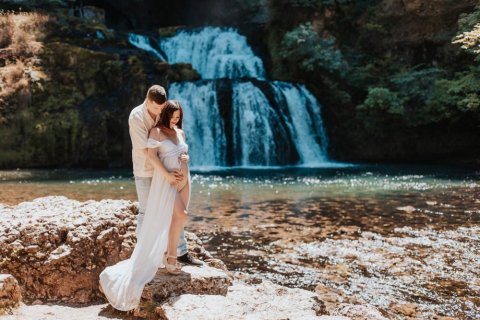 Photographe professionnelle shooting grossesse en pleine nature avec cascade en Franche-Comté