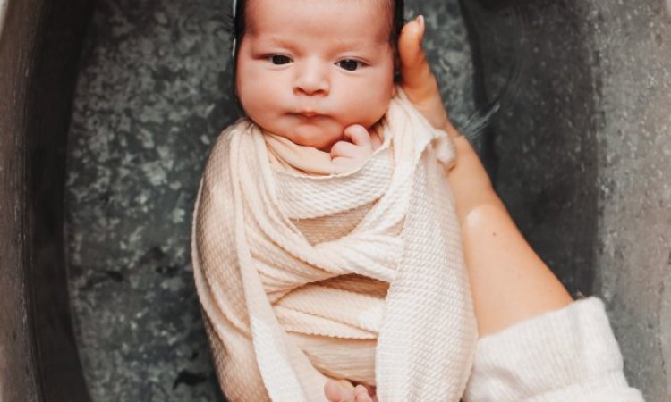 Photographe professionnelle séance photo bain bébé emmailloté à Besançon