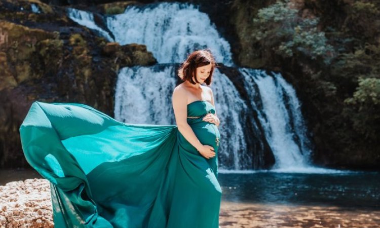 Photographe professionnelle shooting grossesse en pleine nature avec cascade en Franche-Comté