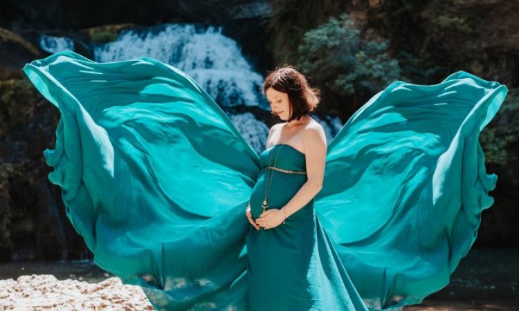 Photographe professionnelle shooting grossesse en pleine nature avec cascade en Franche-Comté