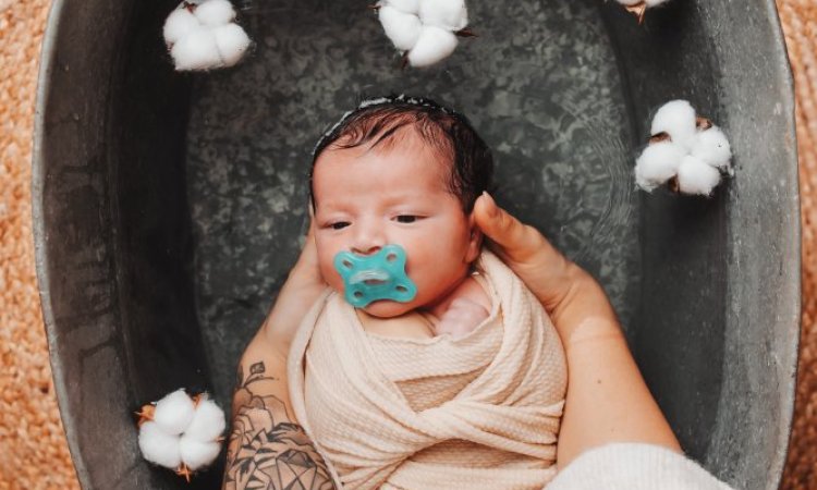 Photographe professionnelle séance photo bain bébé emmailloté à Besançon