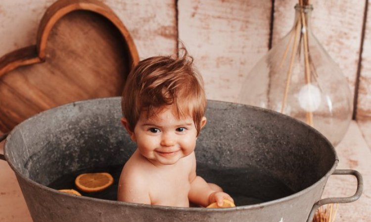 Photographe professionnelle shooting photo anniversaire avec bain bébé en studio à Besançon