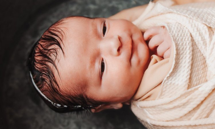 Photographe professionnelle séance photo bain bébé emmailloté à Besançon